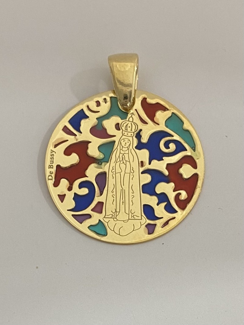 Medalla exclusiva De Bussy Virgen de Fátima en plata de ley 925ml cubierta de oro de 18 Kt y esmalte.

Tamaño: 25mm.